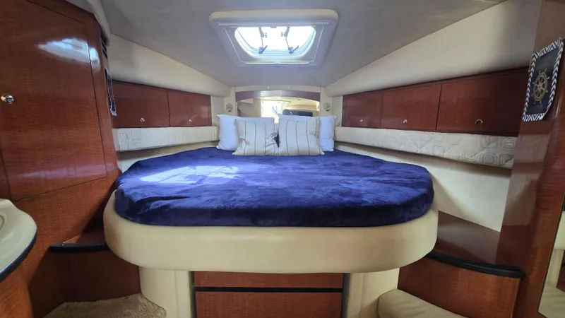 Slide: The Image of 2003 Sea Ray 340 Sundancer cabin with plush bed and wooden cabinetry. - 17