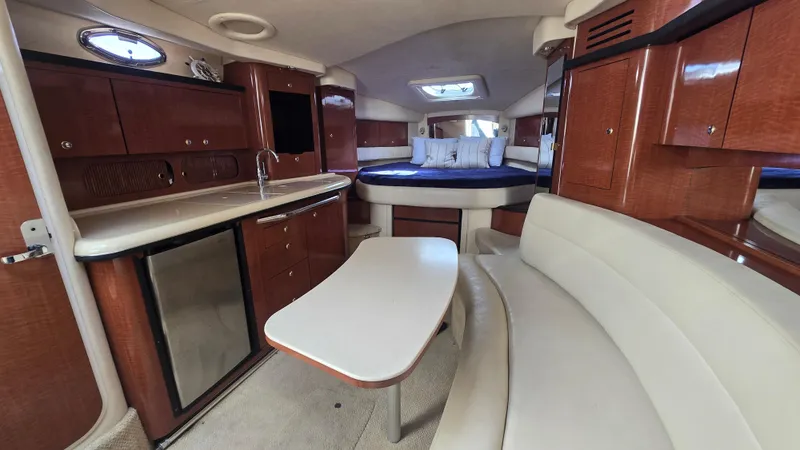 Slide: The Image of 2003 Sea Ray 340 Sundancer interior with kitchenette, seating, and bed. Luxurious yacht cabin design. - 18