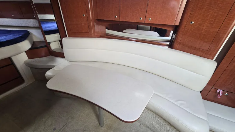 Slide: The Image of Interior of 2003 Sea Ray 340 Sundancer with curved seating and wooden cabinetry. - 19