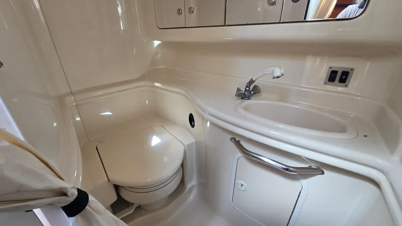 Slide: The Image of 2003 Sea Ray 340 Sundancer bathroom with sink, toilet, and storage cabinets. - 23