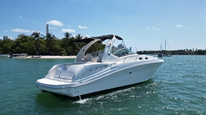 Slide: The Image of 2003 Sea Ray 340 Sundancer boat cruising on a sunny day near a tropical shoreline. - 3