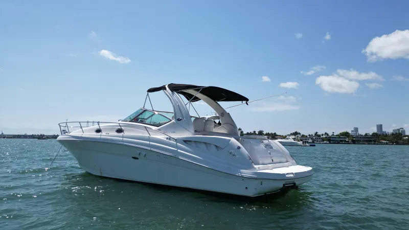 Slide: The Image of 2003 Sea Ray 340 Sundancer yacht on calm water under clear blue sky. - 6
