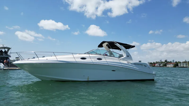 Slide: The Image of 2003 Sea Ray 340 Sundancer boat on calm water under a blue sky. - 7