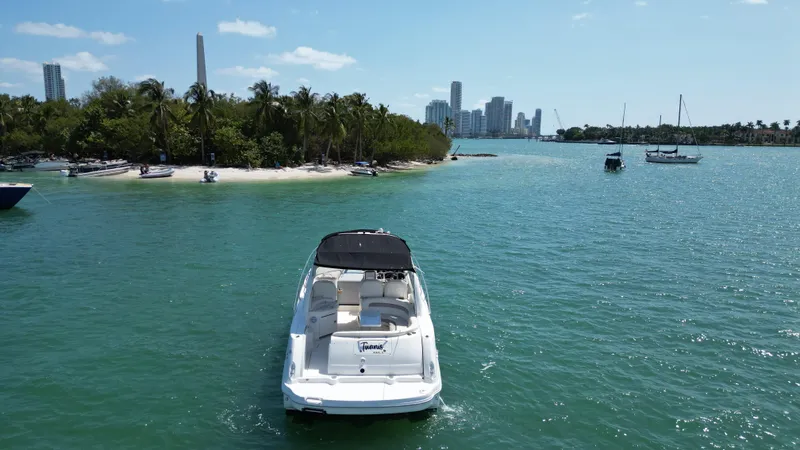 Slide: The Image of 2003 Sea Ray 340 Sundancer boat on turquoise water near a tropical island and city skyline. - 9