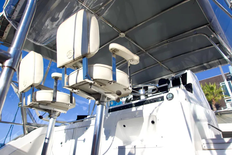 Slide: The Image of 1986 Bertram 46 Sportfisher helm with white captain chairs and canopy. - 12