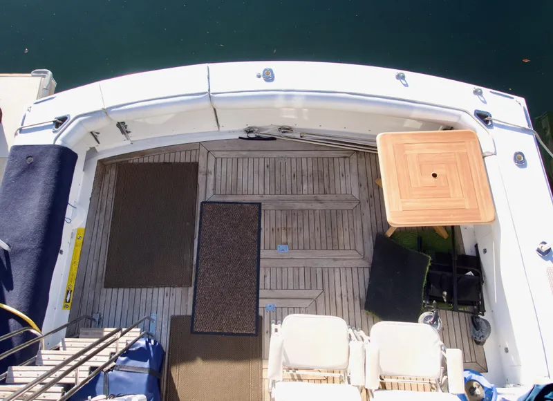 Slide: The Image of 1986 Bertram 46 Sportfisher deck with wooden flooring and seating area. - 16