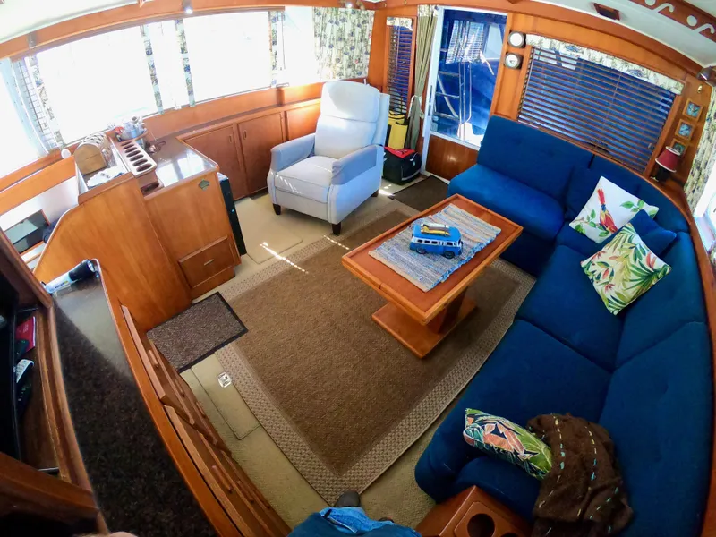 Slide: The Image of Interior of 1986 Bertram 46 Sportfisher with blue seating, wooden table, and nautical decor. - 19