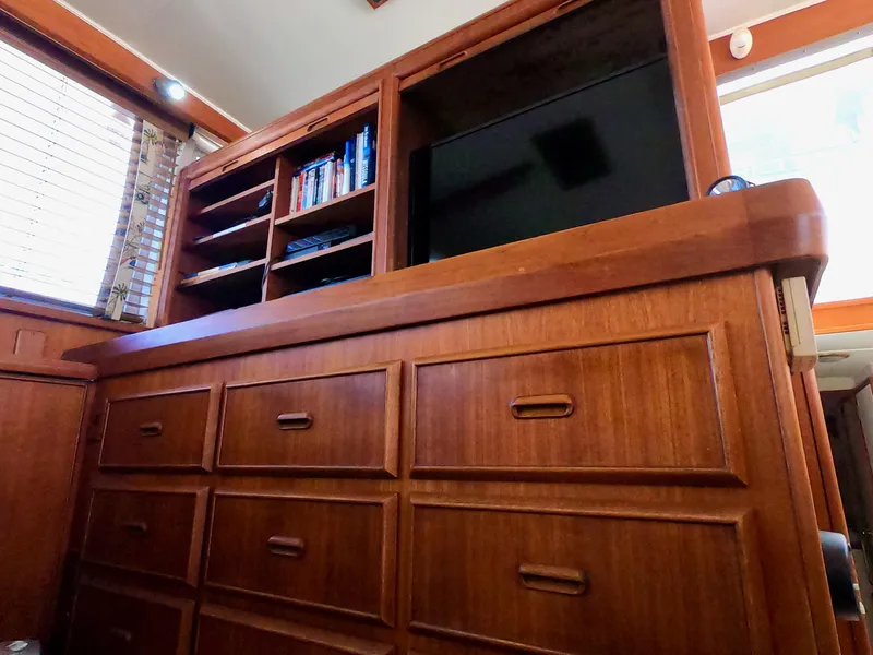 Slide: The Image of 1986 Bertram 46 Sportfisher interior with wooden cabinetry, shelves, and a TV. - 22