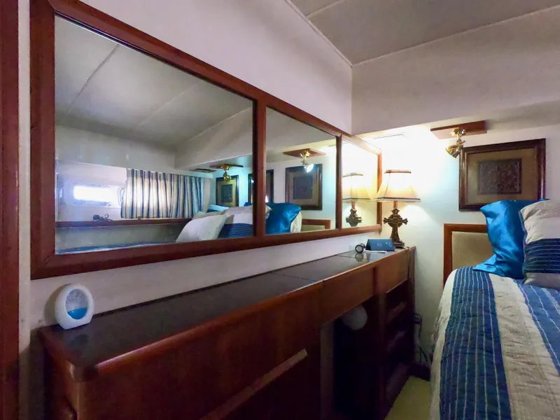 Slide: The Image of Interior of 1986 Bertram 46 Sportfisher with wood accents and cozy bedding. - 30