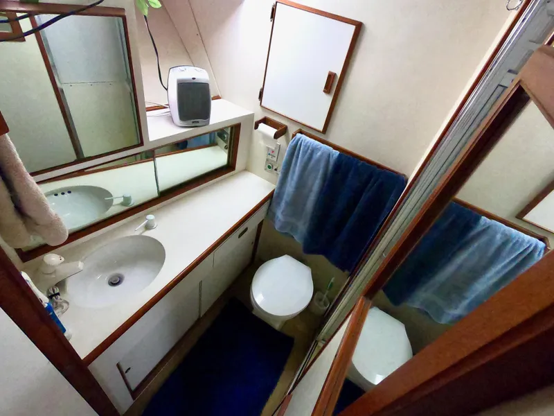 Slide: The Image of 1986 Bertram 46 Sportfisher bathroom with sink, mirror, and blue towel. - 31