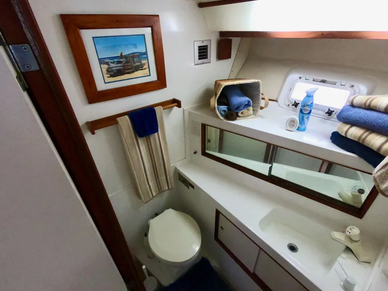Slide: The Image of 1986 Bertram 46 Sportfisher bathroom with mirror, sink, and nautical decor. - 35