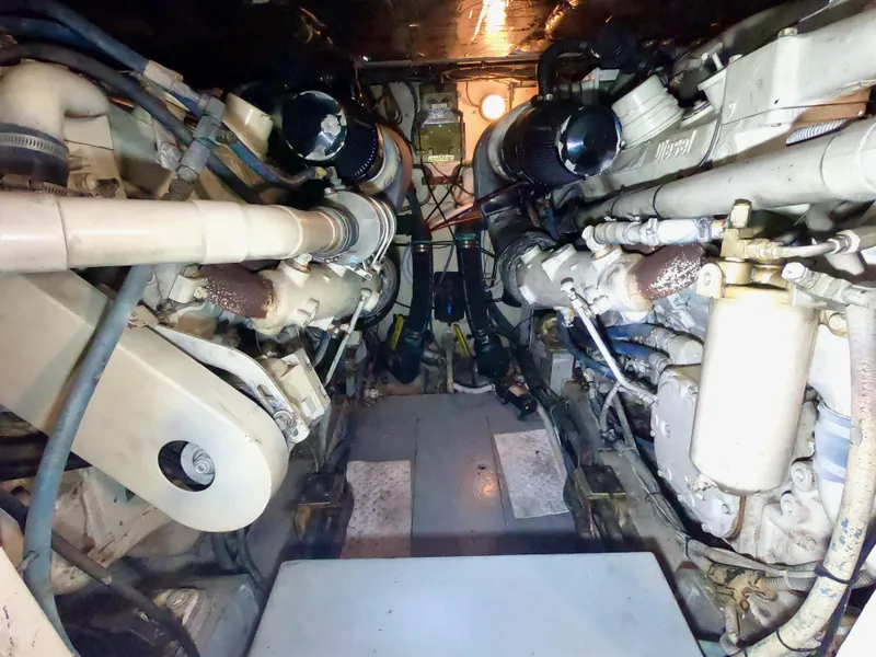 Slide: The Image of Engine room of a 1986 Bertram 46 Sportfisher boat, showcasing dual engines and mechanical components. - 36