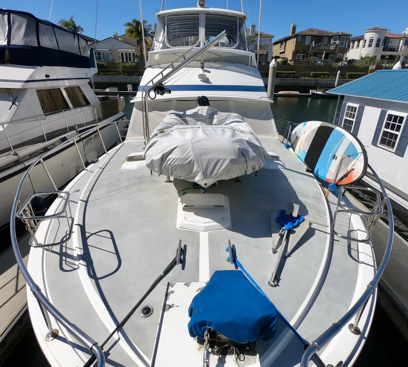 Slide: The Image of 1986 Bertram 46 Sportfisher yacht docked, featuring spacious deck and covered equipment. - 4