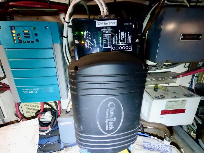 Slide: The Image of Electrical components inside a 1986 Bertram 46 Sportfisher, featuring a 32V inverter and battery charger. - 41