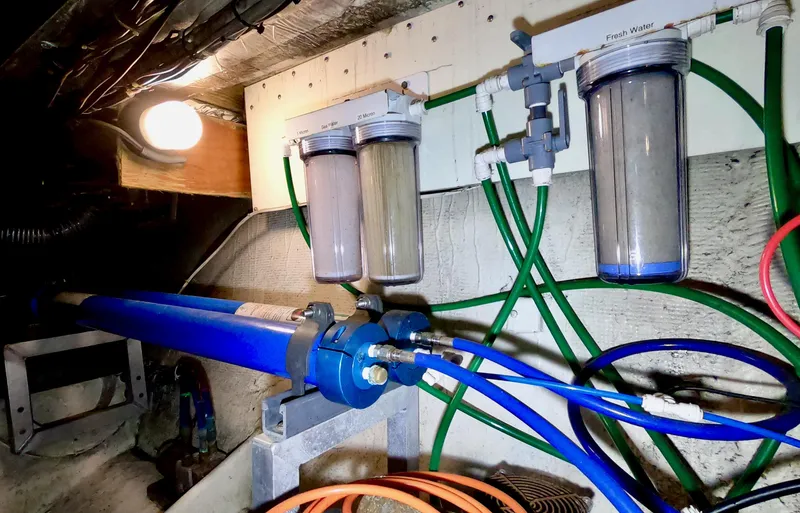 Slide: The Image of Engine room of 1986 Bertram 46 Sportfisher with water filtration system and hoses. - 43