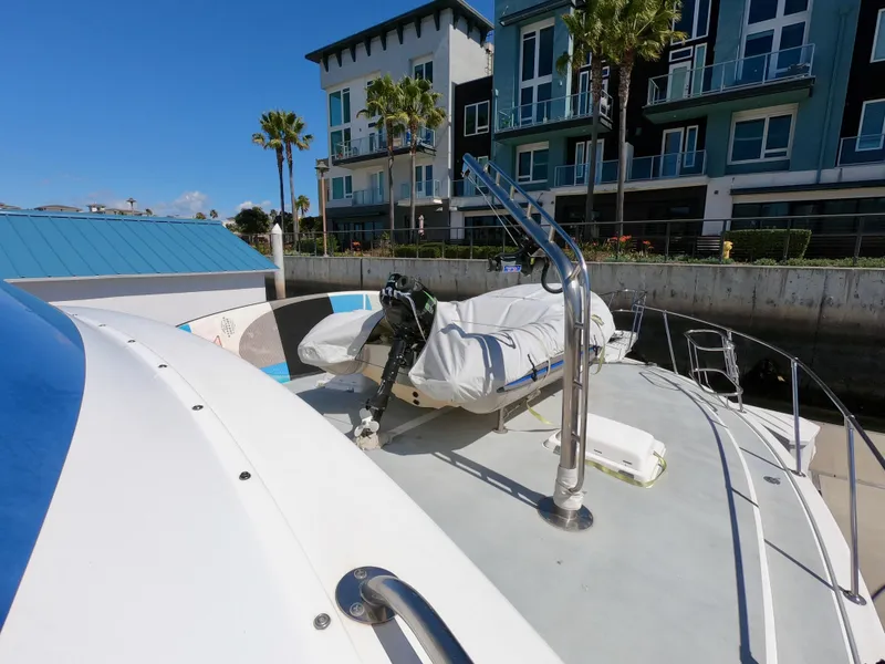 Slide: The Image of 1986 Bertram 46 Sportfisher yacht docked near modern waterfront buildings. - 5