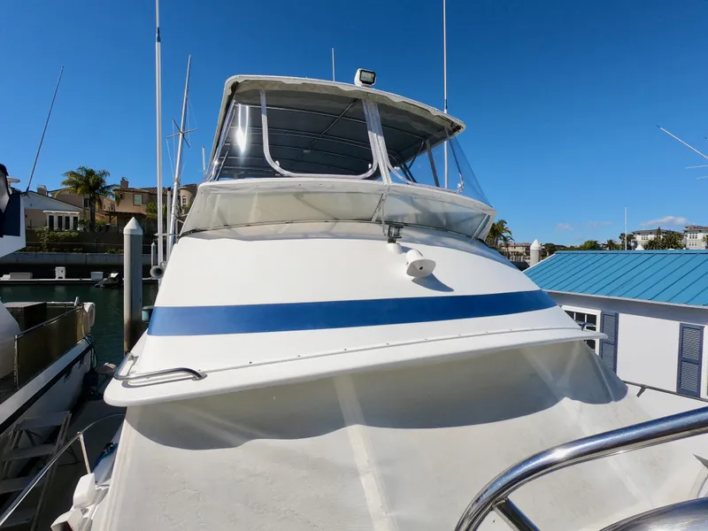 Slide: The Image of 1986 Bertram 46 Sportfisher boat docked under clear blue sky. - 6