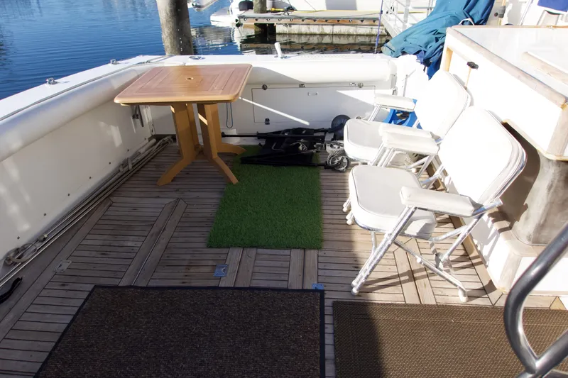 Slide: The Image of 1986 Bertram 46 Sportfisher deck with chairs and table, docked at marina. - 9