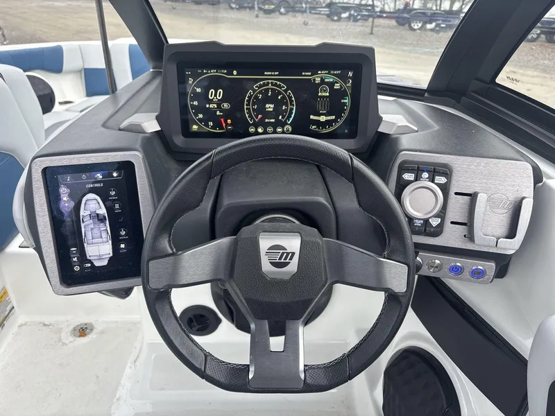 Slide: The Image of 2022 Malibu 21lx boat dashboard with digital displays and steering wheel. - 10