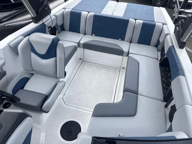Slide: The Image of 2022 Malibu 21lx boat interior with blue and gray seating, spacious layout. - 7