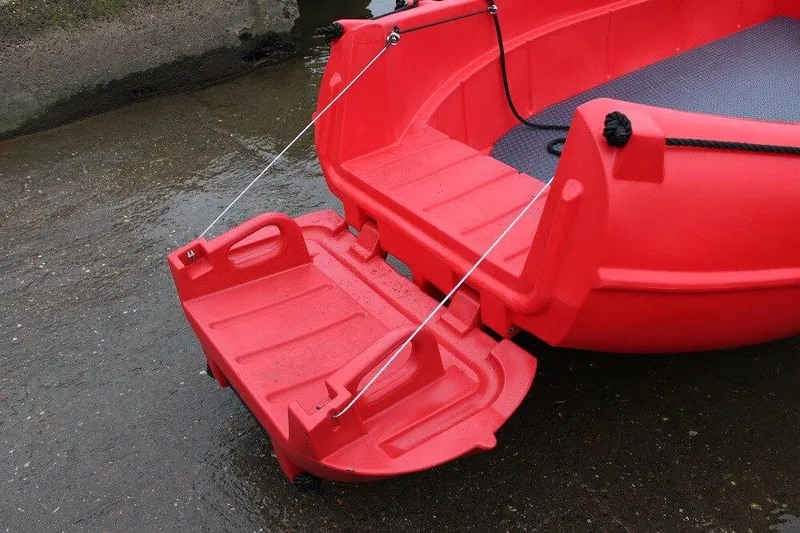Slide: The Image of Red Whaly 500R Pro boat, 2025 model, with a foldable rear step on wet surface. - 12