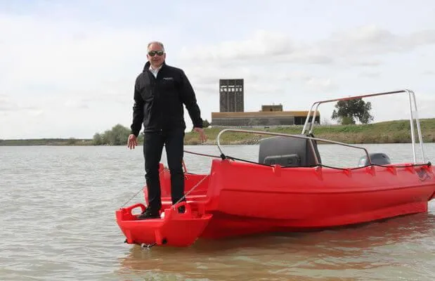 The Image of Man standing on red 2025 Whaly 500R Pro boat in a calm lake. - 5