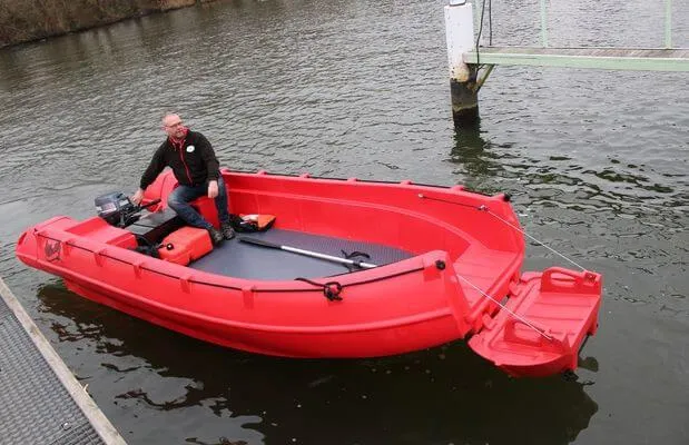 Slide: The Image of Red 2025 Whaly 500R Pro boat with a person onboard, docked on calm water. - 9