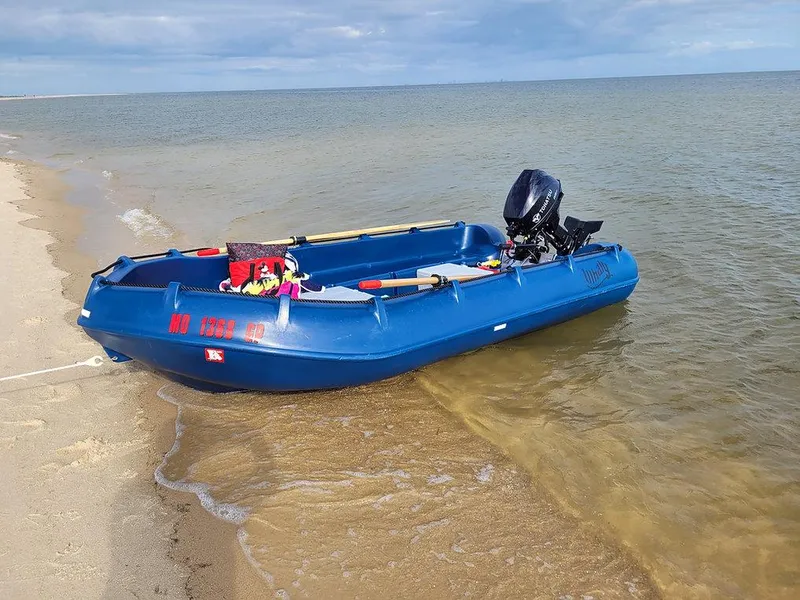 Slide: The Image of Blue Whaly 370 boat, 2025 model, docked on sandy beach with outboard motor. - 11