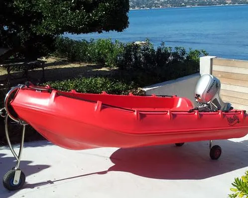 Slide: The Image of Red Whaly 370 boat, 2025 model, with outboard motor, parked near a scenic waterfront. - 6