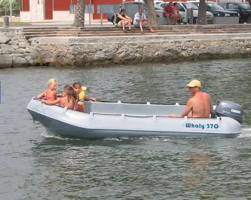 Slide: The Image of Man and children in a Whaly 370 boat on a calm waterway. - 8