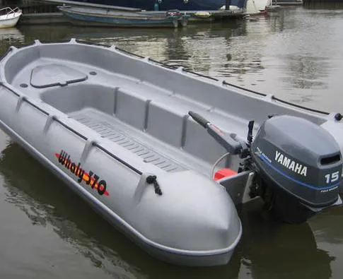 Slide: The Image of 2025 Whaly 370 boat with Yamaha 15 motor, docked on calm water. - 9