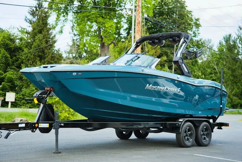 Slide: The Image of 2025 MasterCraft X22 boat parked on trailer outdoors. - 25