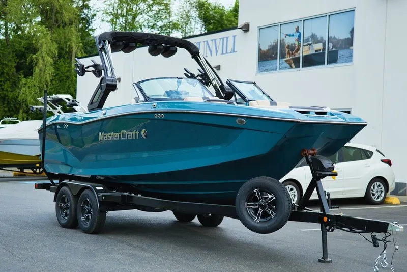 Slide: The Image of 2025 MasterCraft X22 boat on trailer in front of building. - 27