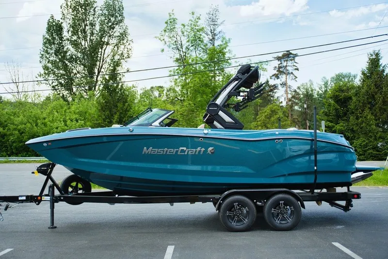 Slide: The Image of 2025 MasterCraft X22 boat parked on trailer outdoors. - 28