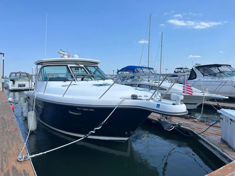 Slide: The Image of 2006 Tiara Yachts 3200 Open docked, featuring sleek design and American flag. - 1