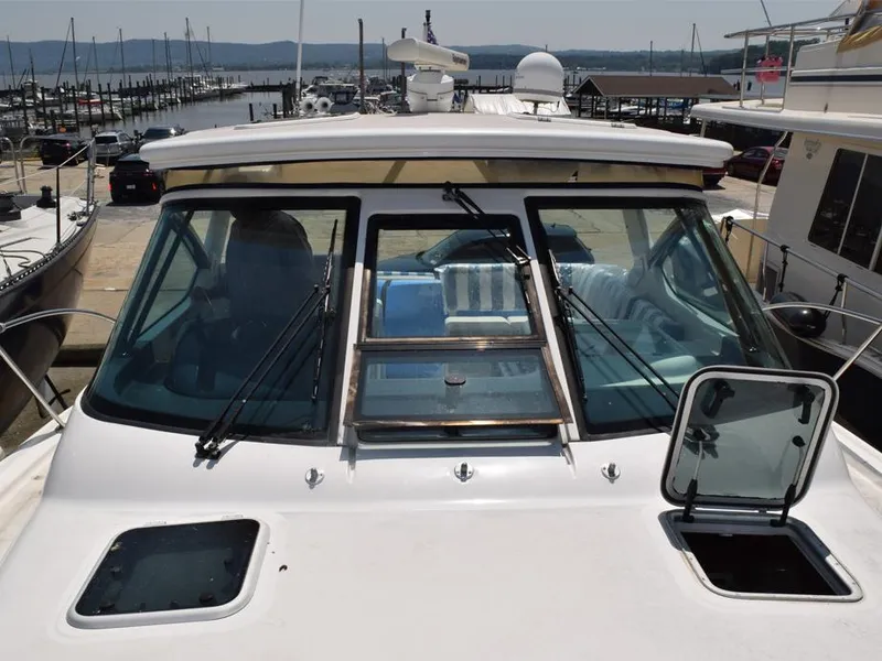 Slide: The Image of 2006 Tiara Yachts 3200 Open at marina, showcasing windshield and open hatch. - 13