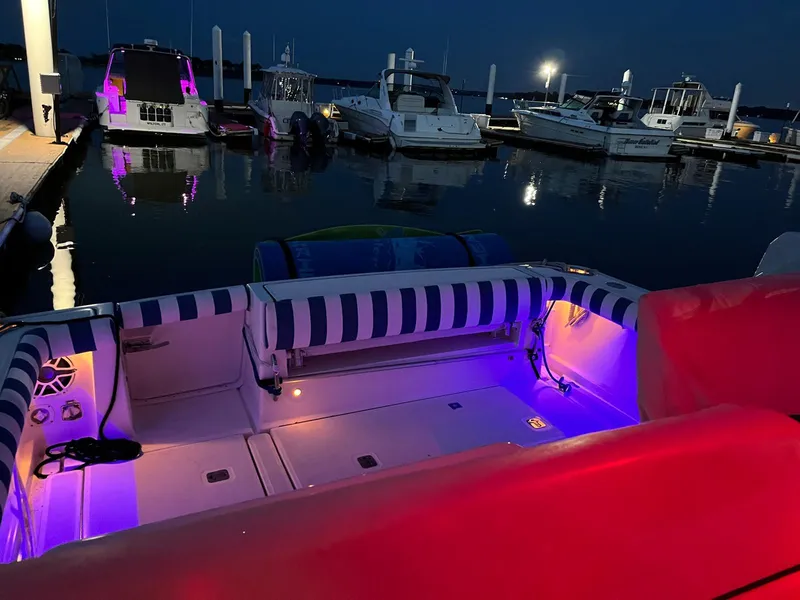 Slide: The Image of 2006 Tiara Yachts 3200 Open with colorful deck lights at night in marina. - 28