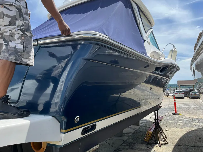 Slide: The Image of 2006 Tiara Yachts 3200 Open boat on dry dock, blue hull, person standing nearby. - 5
