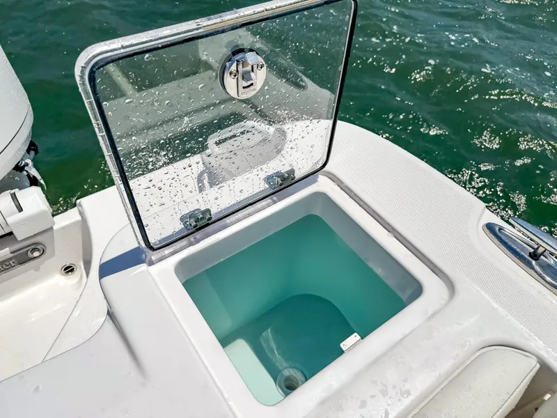Slide: The Image of Open storage compartment on 2025 Edgewater 262 CX boat, with clear water view. - 39