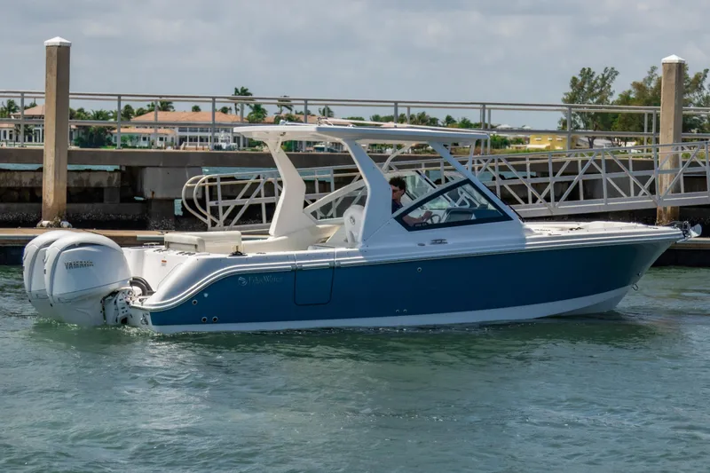 Slide: The Image of 2025 Edgewater 262 CX boat docked in marina, featuring sleek design and Yamaha outboard engine. - 4