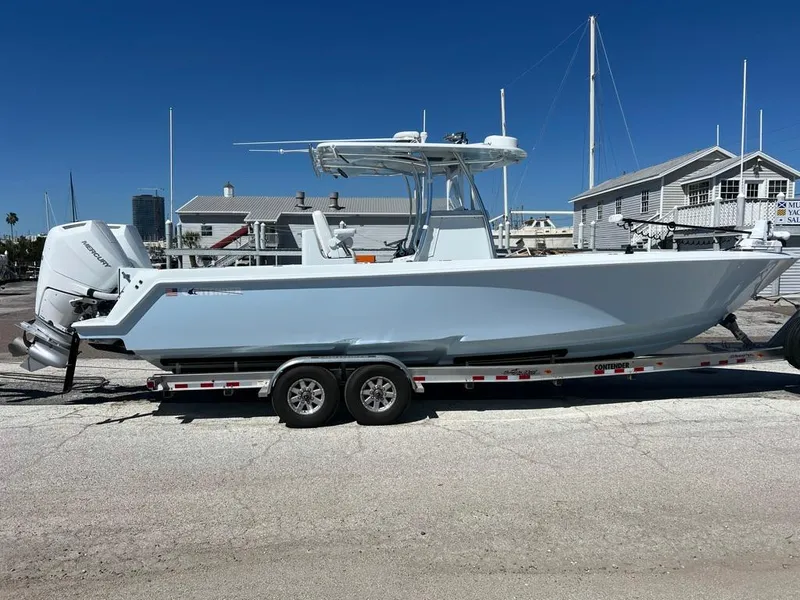 Slide: The Image of 2025 Contender 32 ST boat on trailer, parked outdoors under clear blue sky. - 1