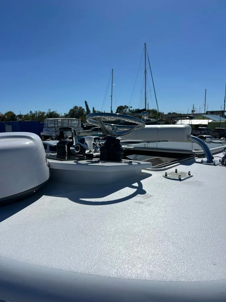 Slide: The Image of 2025 Contender 32 ST boat deck with steering wheel under clear blue sky. - 10