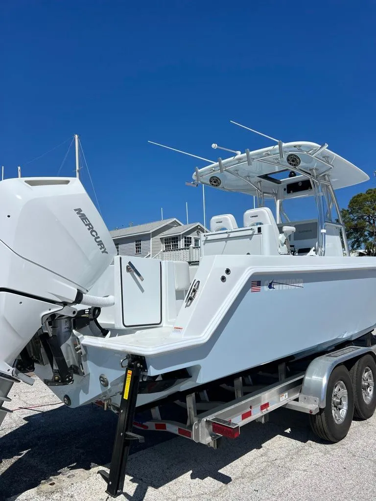 Slide: The Image of 2025 Contender 32 ST boat with Mercury engine on trailer, parked outdoors. - 2