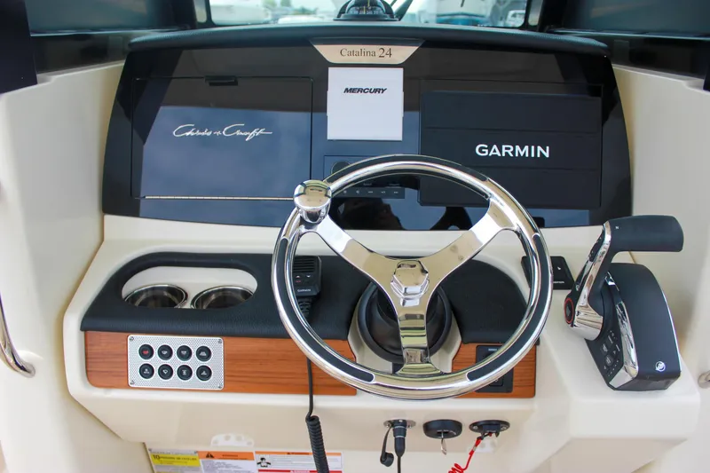 Slide: The Image of 2024 Chris-Craft Catalina 24 dashboard with Garmin and Mercury controls. - 2