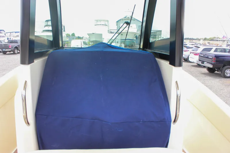 Slide: The Image of 2024 Chris-Craft Catalina 24 boat with blue cover, parked in a marina. - 23