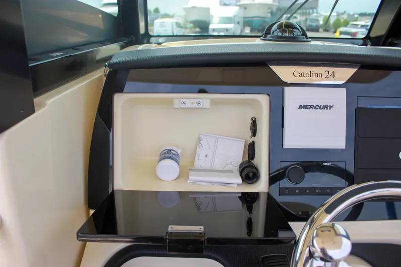 Slide: The Image of 2024 Chris-Craft Catalina 24 dashboard with storage compartment and Mercury controls. - 29