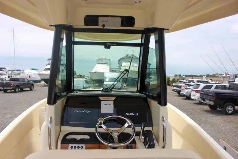Slide: The Image of 2024 Chris-Craft Catalina 24 boat dashboard with steering wheel and Garmin navigation system. - 34