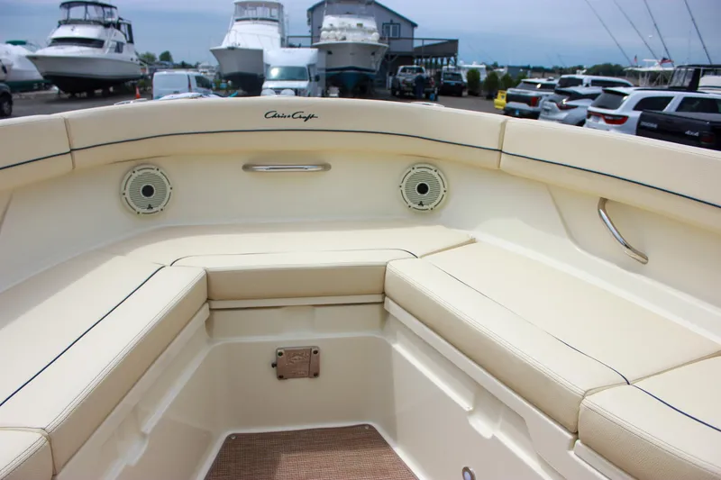 Slide: The Image of 2024 Chris-Craft Catalina 24 boat interior with beige seating and speakers, docked at a marina. - 36
