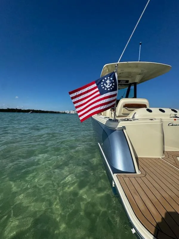 Slide: The Image of 2024 Chris-Craft Catalina 24 boat on clear water with American flag. - 49