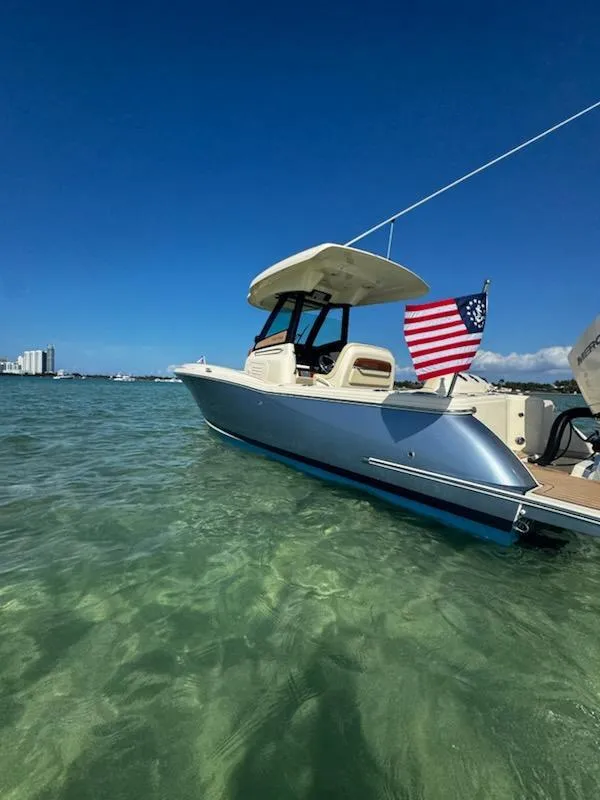 Slide: The Image of 2024 Chris-Craft Catalina 24 boat in clear water, American flag, sunny day. - 54